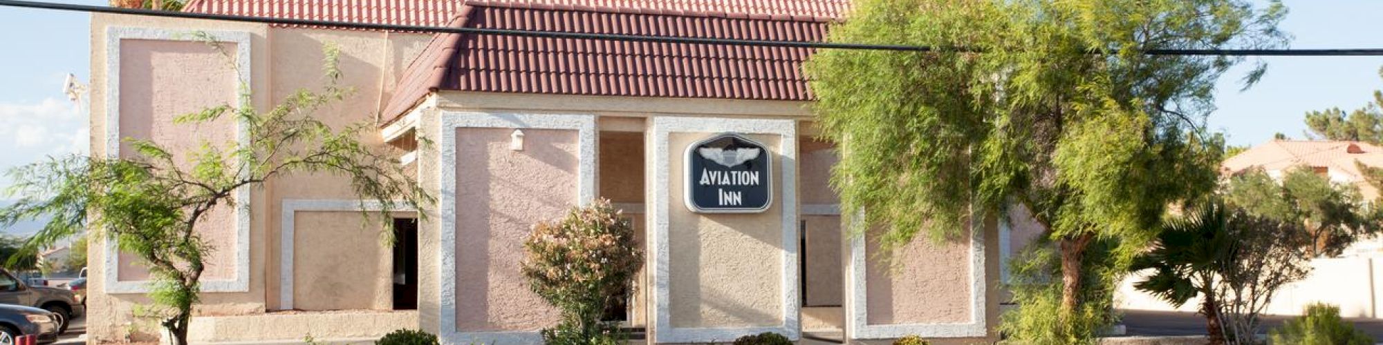 A beige building with a red roof and a sign reading 